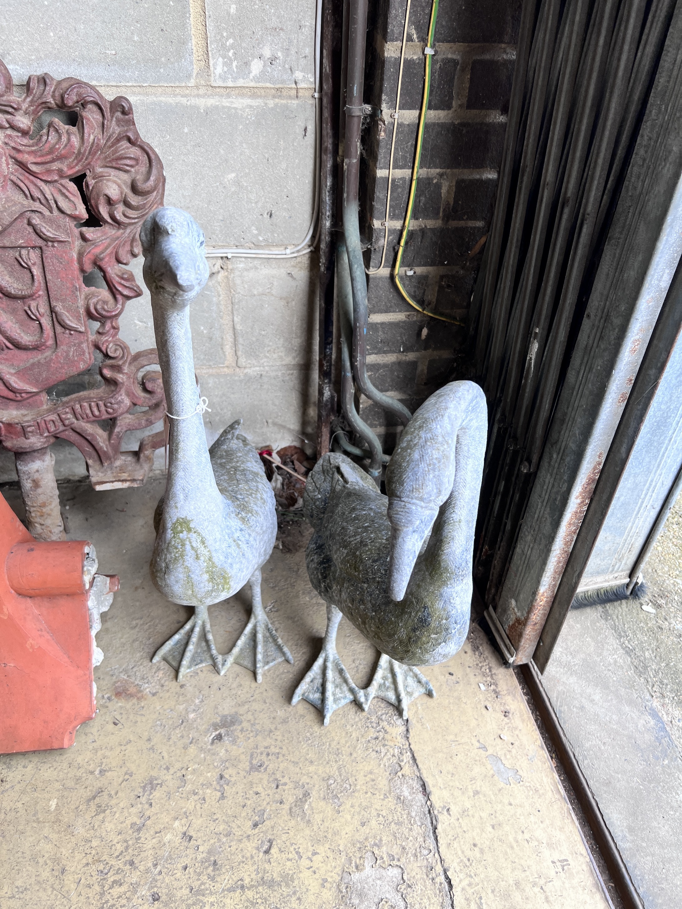 A pair of oxidised metal garden ornaments modelled as geese, height 73cm